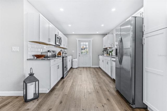 1543 Gentry St, Clearwater, FL 33755 - kitchen featuring white cabinets, appliances with stainless steel finishes, and light wood finished floors