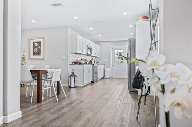1543 Gentry St, Clearwater, FL 33755 - kitchen featuring visible vents, baseboards, light wood-style floors, white cabinetry, and stainless steel appliances