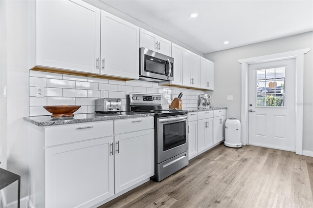 1543 Gentry St, Clearwater, FL 33755 - kitchen featuring light wood finished floors, stainless steel appliances, recessed lighting, white cabinetry, and tasteful backsplash