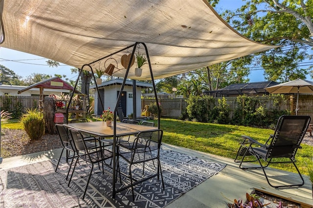 1543 Gentry St, Clearwater, FL 33755 - view of patio / terrace featuring an outbuilding, outdoor dining area, a fenced backyard, and a shed