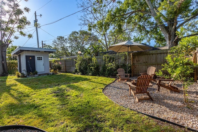 1543 Gentry St, Clearwater, FL 33755 - view of yard featuring an outdoor structure, a shed, a fenced backyard, and an outdoor fire pit