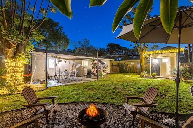 1543 Gentry St, Clearwater, FL 33755 - yard at night featuring fence private yard, an outdoor structure, a shed, an outdoor fire pit, and a patio