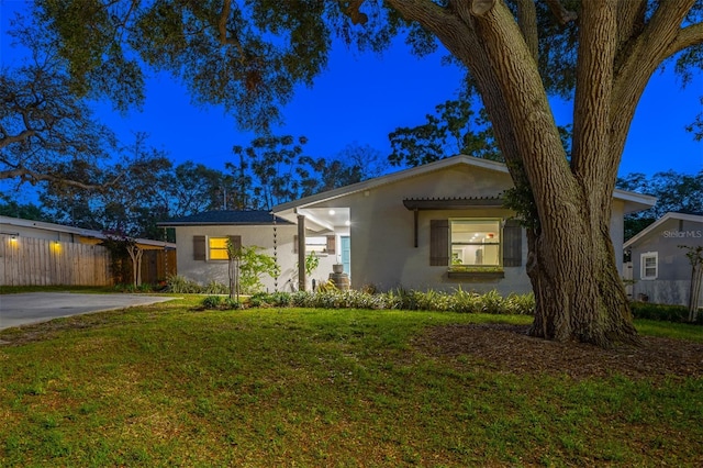 1543 Gentry St, Clearwater, FL 33755 - view of front of house with fence, a front yard, and stucco siding