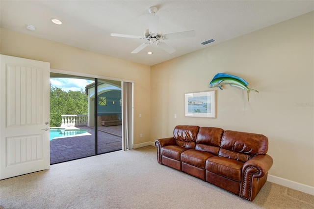 living area with baseboards, visible vents, and carpet floors