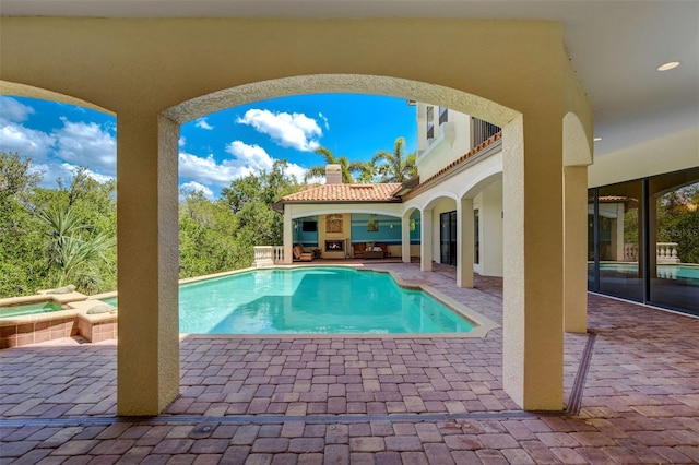 view of swimming pool with a pool with connected hot tub and a patio