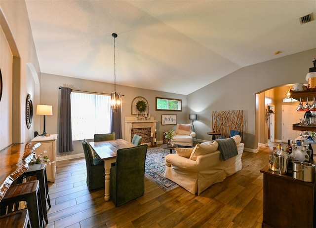 living area featuring arched walkways, dark wood-type flooring, visible vents, and lofted ceiling