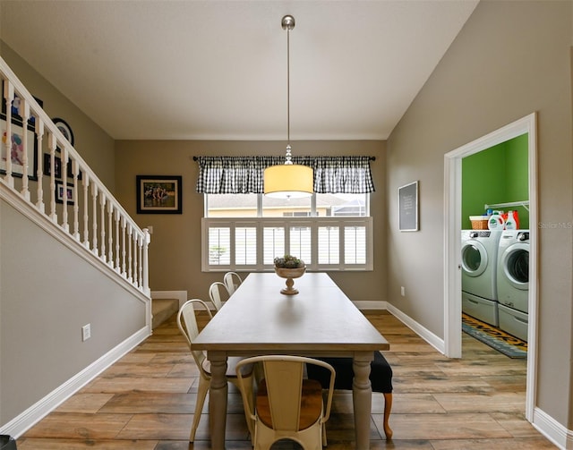 dining area featuring washer and clothes dryer, light wood-type flooring, baseboards, and stairs