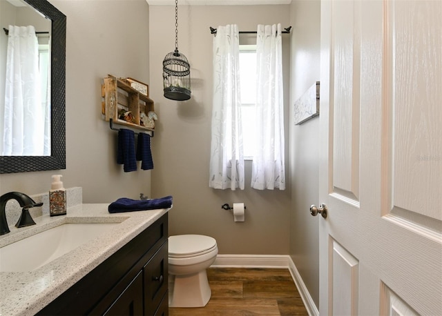bathroom with vanity, baseboards, toilet, and wood finished floors