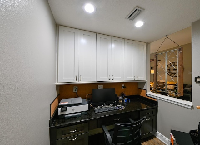 office featuring visible vents, baseboards, and wood finished floors