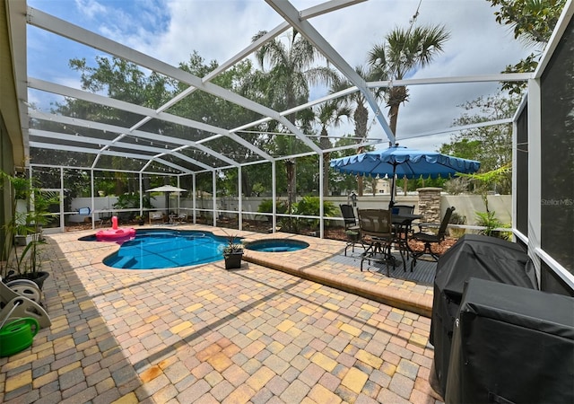 view of pool with a patio area, an in ground hot tub, a fenced backyard, and a lanai