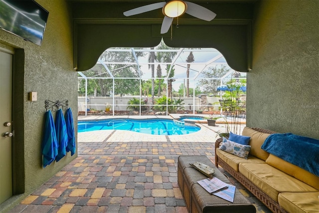 view of swimming pool featuring a lanai, an outdoor living space, a patio area, and a ceiling fan