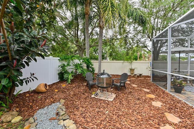 view of yard with a patio area, a fenced backyard, and a lanai
