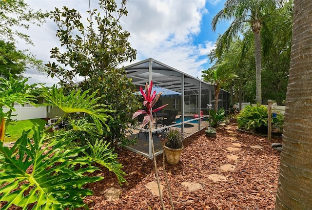 view of yard with an outdoor pool, a fenced backyard, a patio, and a lanai