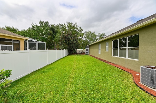 view of yard with central AC unit and a fenced backyard
