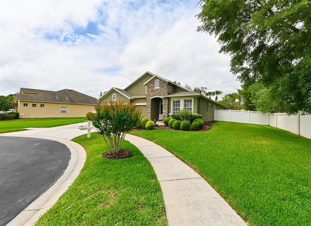 view of front of property featuring a front yard, fence, and stucco siding