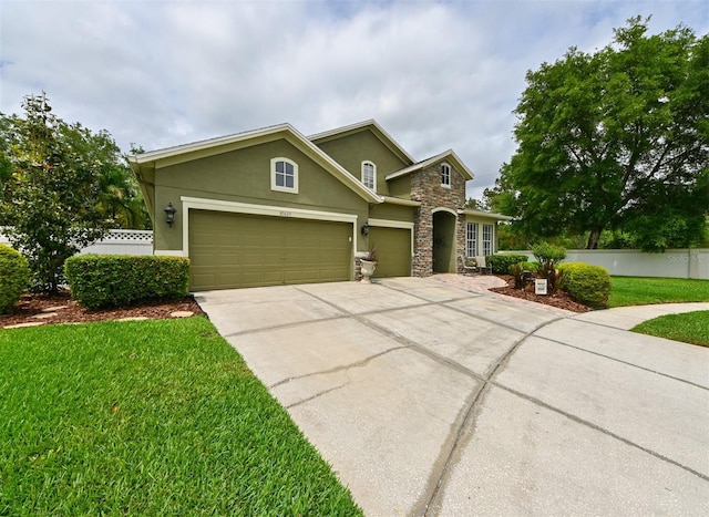 view of front of house featuring a garage, stucco siding, a front yard, stone siding, and concrete driveway