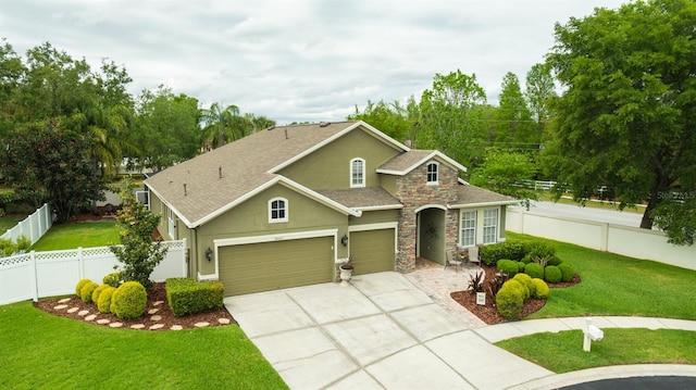 view of front of property featuring a front lawn, fence private yard, a garage, and stucco siding