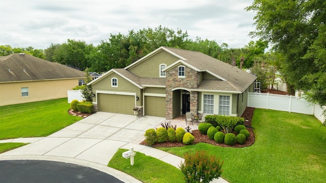 view of front facade with stucco siding, stone siding, a front yard, a garage, and fence