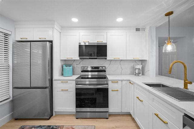 6051 Sun Blvd Unit 111, Saint Petersburg, FL 33715 - kitchen with a sink, white cabinets, visible vents, and appliances with stainless steel finishes