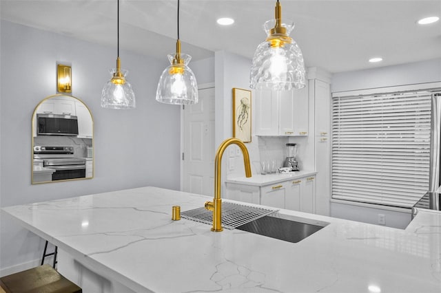 6051 Sun Blvd Unit 111, Saint Petersburg, FL 33715 - kitchen with a sink, light stone countertops, hanging light fixtures, stainless steel appliances, and white cabinets