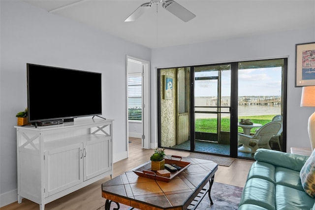 6051 Sun Blvd Unit 111, Saint Petersburg, FL 33715 - living area with light wood finished floors, baseboards, a water view, and a ceiling fan