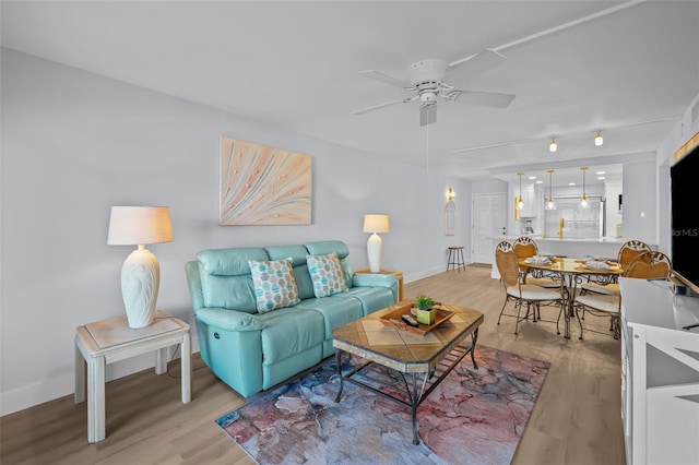 6051 Sun Blvd Unit 111, Saint Petersburg, FL 33715 - living room featuring baseboards, ceiling fan, and light wood-style flooring