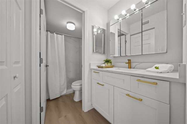6051 Sun Blvd Unit 111, Saint Petersburg, FL 33715 - bathroom featuring a shower with shower curtain, toilet, vanity, wood finished floors, and visible vents