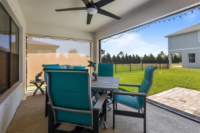 view of patio with outdoor dining space, fence, and a ceiling fan
