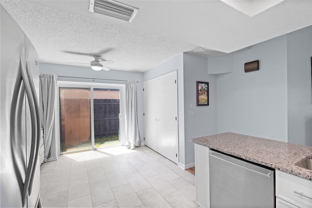 11368 93rd St, Largo, FL 33773 - kitchen featuring freestanding refrigerator, stainless steel dishwasher, ceiling fan, white cabinetry, and light stone counters