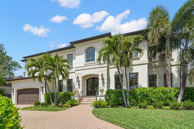 5025 W Homer Ave, Tampa, FL 33629 - mediterranean / spanish house with french doors, a garage, stucco siding, and decorative driveway