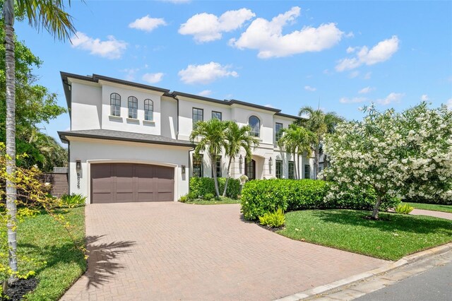 5025 W Homer Ave, Tampa, FL 33629 - mediterranean / spanish-style home featuring an attached garage, stucco siding, a front lawn, and decorative driveway
