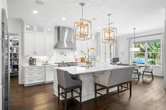 5025 W Homer Ave, Tampa, FL 33629 - kitchen featuring light countertops, dark wood finished floors, wall chimney exhaust hood, and backsplash