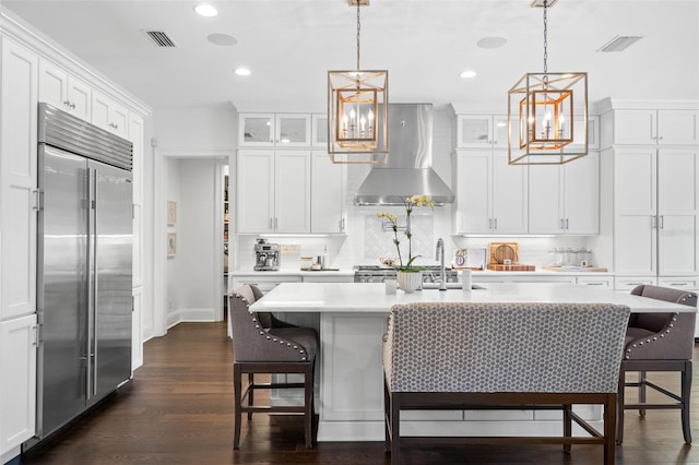 5025 W Homer Ave, Tampa, FL 33629 - kitchen featuring light countertops, stainless steel built in refrigerator, wall chimney exhaust hood, and visible vents