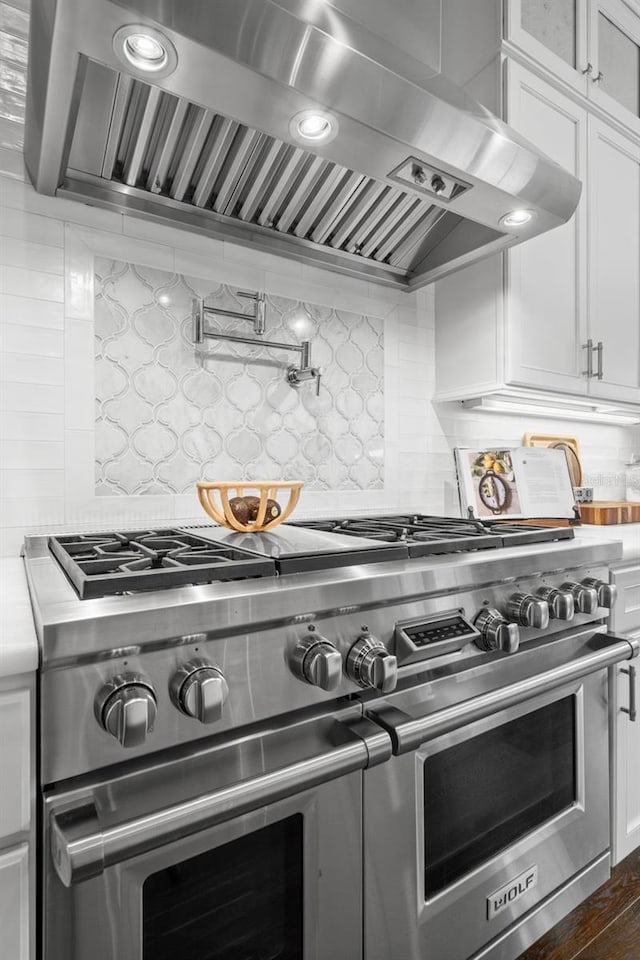5025 W Homer Ave, Tampa, FL 33629 - kitchen featuring tasteful backsplash, white cabinets, wall chimney exhaust hood, light countertops, and double oven range