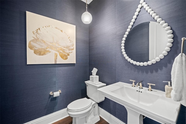5025 W Homer Ave, Tampa, FL 33629 - half bathroom with baseboards, a sink, toilet, and wood finished floors