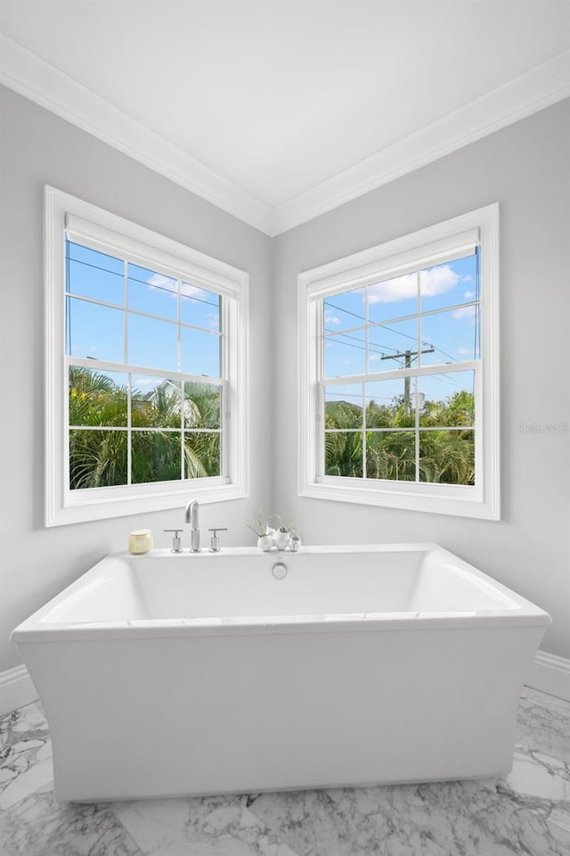 5025 W Homer Ave, Tampa, FL 33629 - bathroom featuring ornamental molding, baseboards, marble finish floor, and a freestanding tub