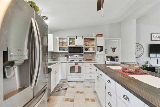 kitchen with white cabinetry, vaulted ceiling, stainless steel appliances, and tasteful backsplash