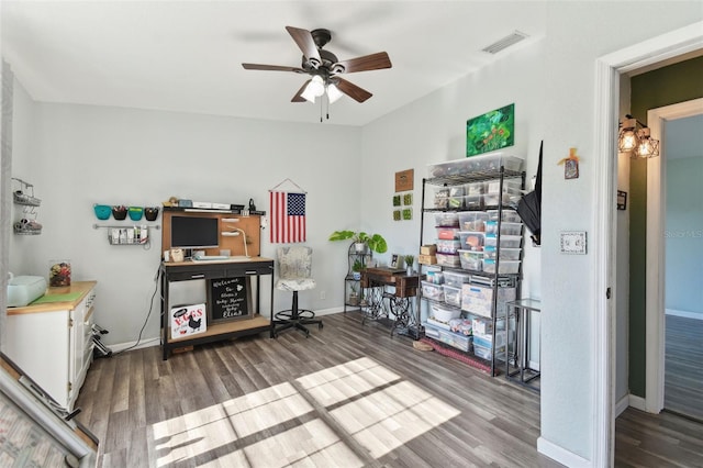 home office with a ceiling fan, wood finished floors, baseboards, and visible vents