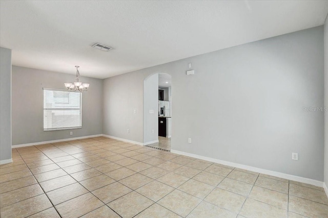 10524 White Peacock Pl, Riverview, FL 33578 - spare room featuring arched walkways, light tile patterned floors, a chandelier, and baseboards