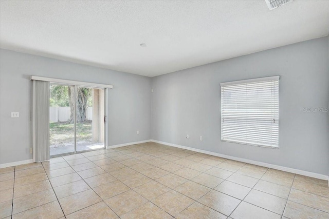 10524 White Peacock Pl, Riverview, FL 33578 - spare room featuring light tile patterned floors, baseboards, and a textured ceiling