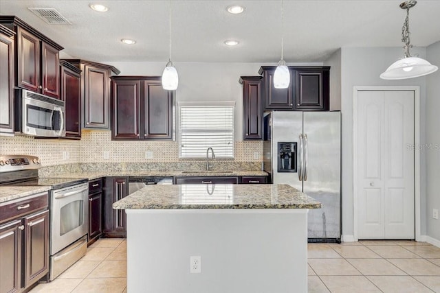 10524 White Peacock Pl, Riverview, FL 33578 - kitchen with appliances with stainless steel finishes, a sink, light tile patterned floors, a kitchen island, and recessed lighting