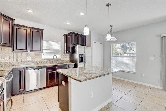 10524 White Peacock Pl, Riverview, FL 33578 - kitchen with appliances with stainless steel finishes, a sink, decorative backsplash, plenty of natural light, and a textured ceiling