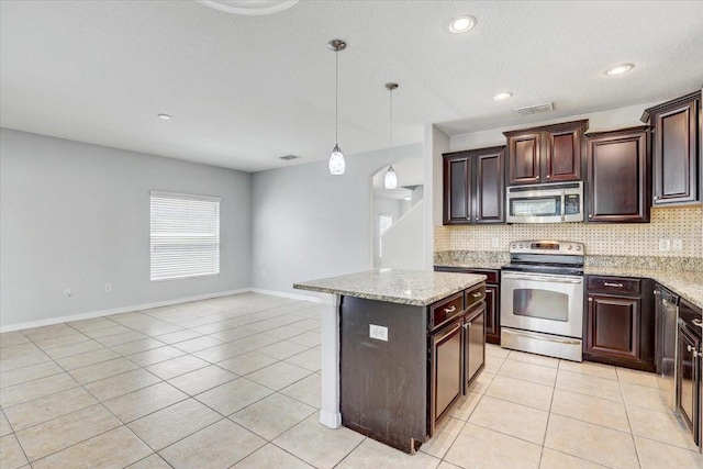 10524 White Peacock Pl, Riverview, FL 33578 - kitchen featuring appliances with stainless steel finishes, decorative backsplash, light tile patterned floors, hanging light fixtures, and recessed lighting