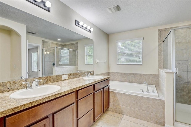 10524 White Peacock Pl, Riverview, FL 33578 - bathroom featuring a bath, a shower stall, tile patterned floors, double vanity, and a textured ceiling