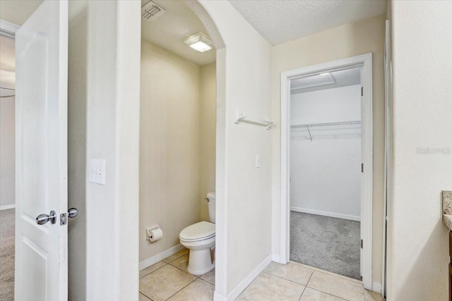 10524 White Peacock Pl, Riverview, FL 33578 - bathroom featuring toilet, tile patterned floors, a walk in closet, and baseboards