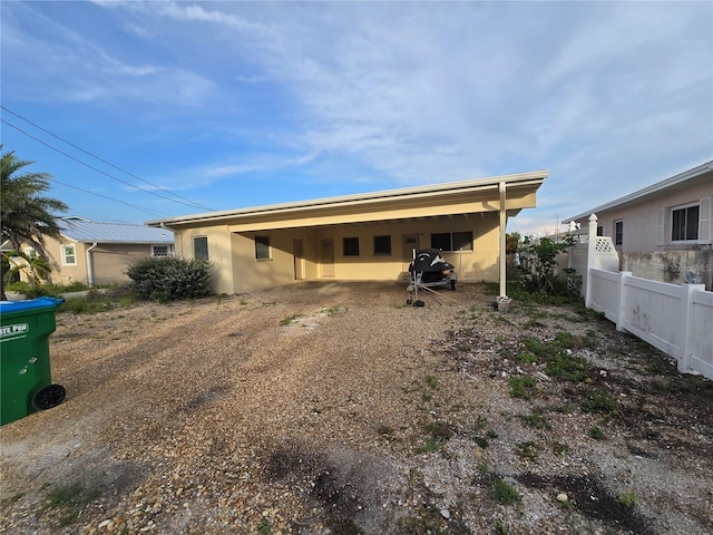 249 144th Ave, Madeira Beach, FL 33708 - rear view of house featuring dirt driveway and stucco siding