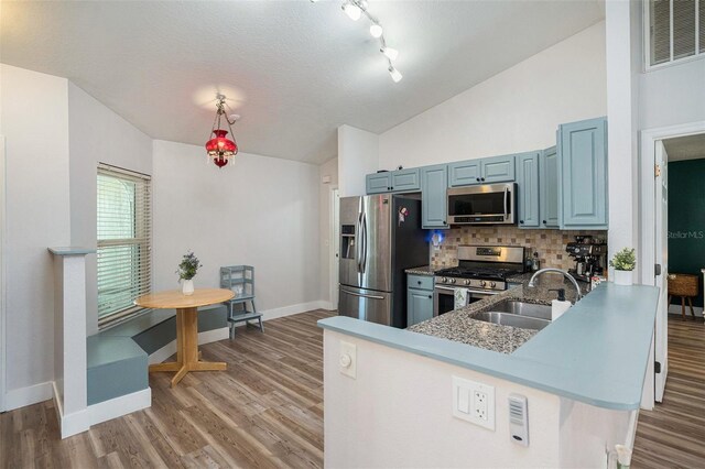 1601 14th St W, Palmetto, FL 34221 - kitchen with appliances with stainless steel finishes, a sink, baseboards, vaulted ceiling, and tasteful backsplash