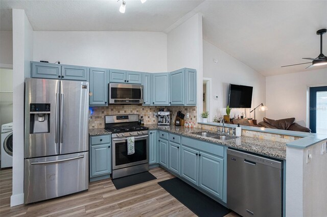1601 14th St W, Palmetto, FL 34221 - kitchen featuring appliances with stainless steel finishes, a sink, blue cabinetry, washer / clothes dryer, and a peninsula