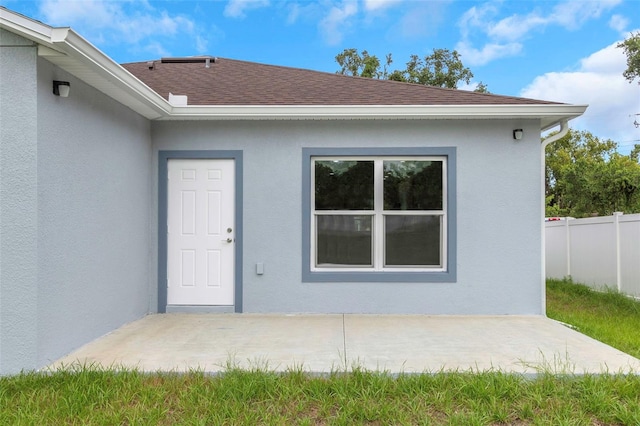 8505 N Brooks St, Tampa, FL 33604 - property entrance featuring roof with shingles, stucco siding, and a patio