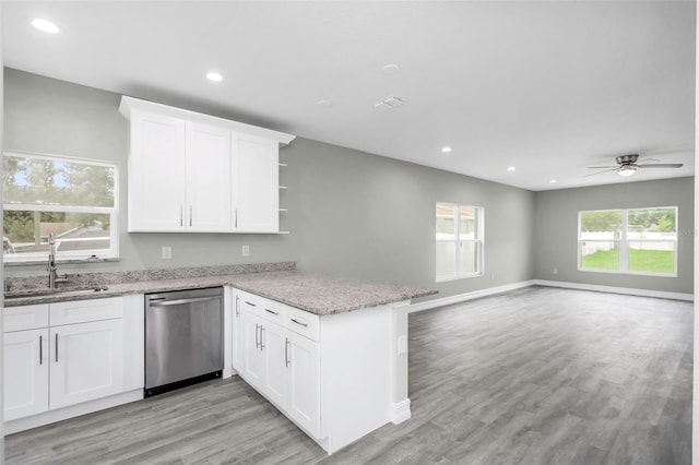 8505 N Brooks St, Tampa, FL 33604 - kitchen featuring stainless steel dishwasher, a sink, a peninsula, open shelves, and white cabinets